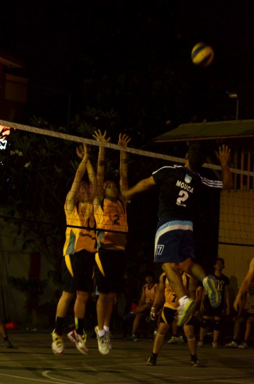 A Faculty player goes up for the spike against two Accountancy Players. Photo by Regine Recede