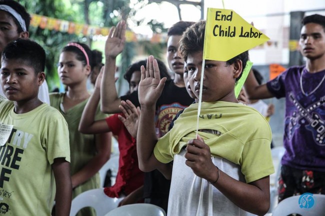Former child laborers raise flags to protest against child labor. Photo by Mark Louie Balladares