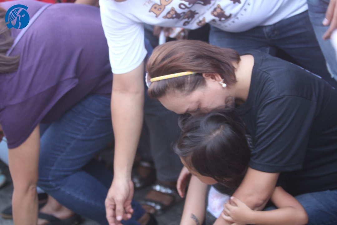A mother embracing her child as they both laid flowers in memory of the Roxas bombing victims. Photo by Anna Sophia Tarhata Piang