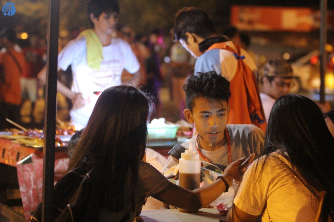 RESTART. An avid Roxas night market shopper playfully eats with his friends at a food stall. Their smiles and laughter contributed to the rebuild of broken yesterday caused by a terror attack. Photo by Ram Manlatican